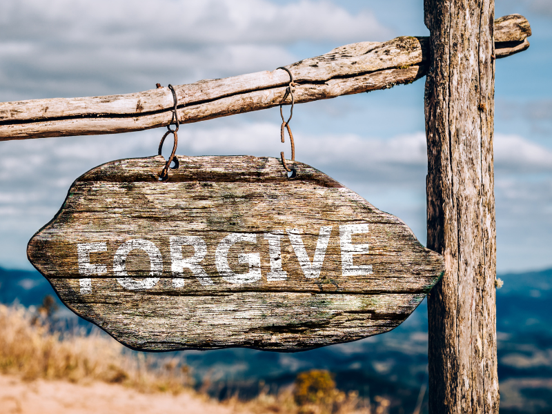 Warum Vergebung befreit, innere Heilung, Schild mit der Aufschrift Forgive, im Hintergrund Meer
